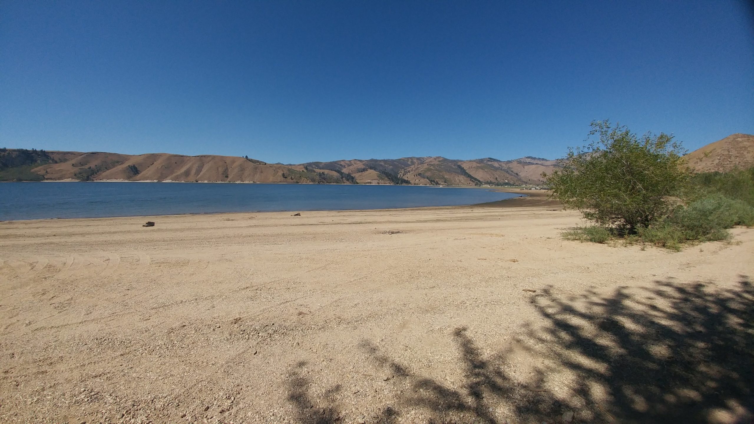 large dry lake shore in front of anderson ranch reservoir with mountains in the background